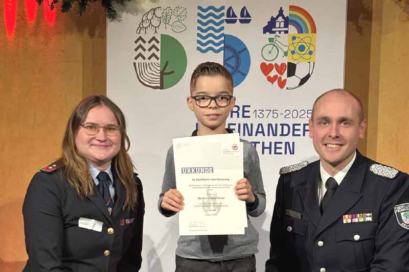 Marlon Heide (mi.), der kleine Zeuthener Held bewies Mut. Anja Lehmann (li.), Landesjugendfeuerwehrwartin und Wehrführer der Freiwilligen Feuerwehr Zeuthen, Stefan Wehner (re.) , (Foto: Mende/Gemeinde Zeuthen)