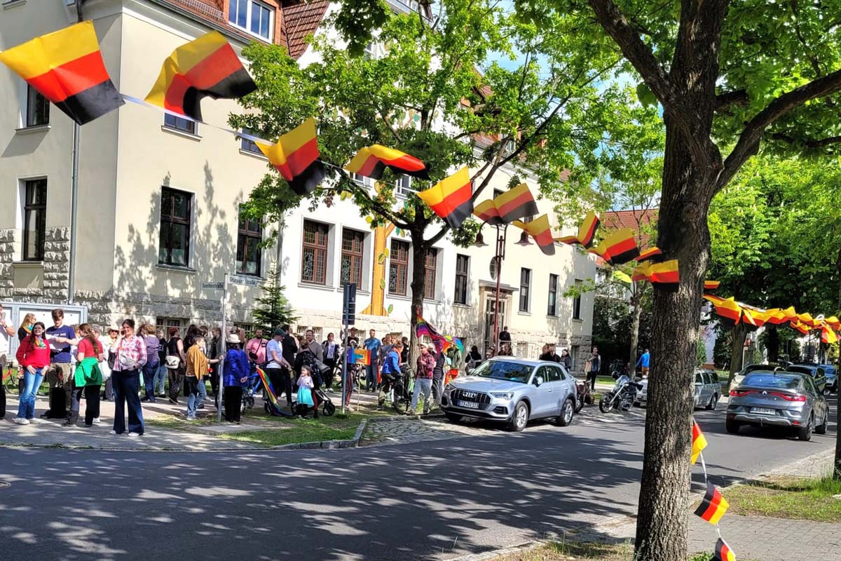 Rathaus Eichwalde: Einige Anhänger sind bei der Hissung der Regenbogenfahne dabei. Aber auch ihre